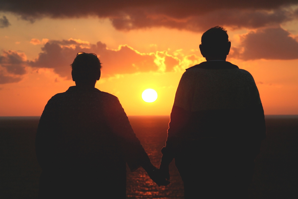 Photo of an elderly couple watching sunset.